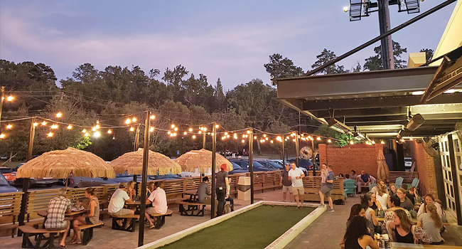 outdoor dining and games with string lighting at Jarfly