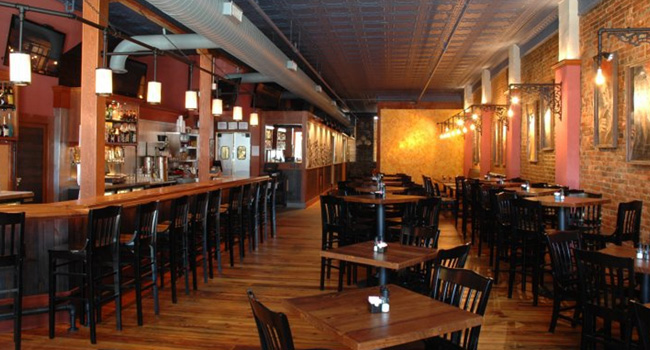 inside of Loft restaurant showing the bar with stools and tables
